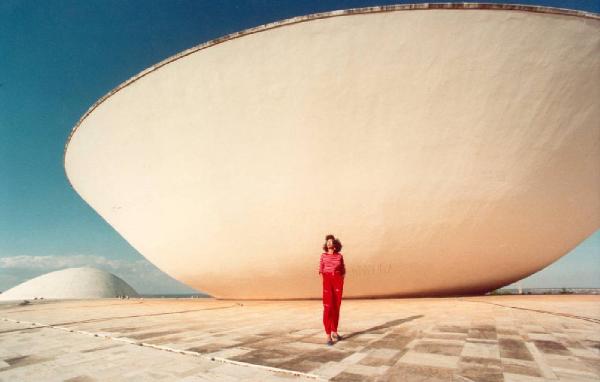 Brasilia. Figura femminile (Cyssa) davanti alla cupola rovesciata del Congresso Nazionale