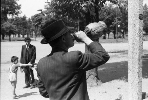 Milano. Parco Sempione. Un uomo beve da un fiaschetto dell'acqua in prossimità della "Fontana dell'acqua marcia"