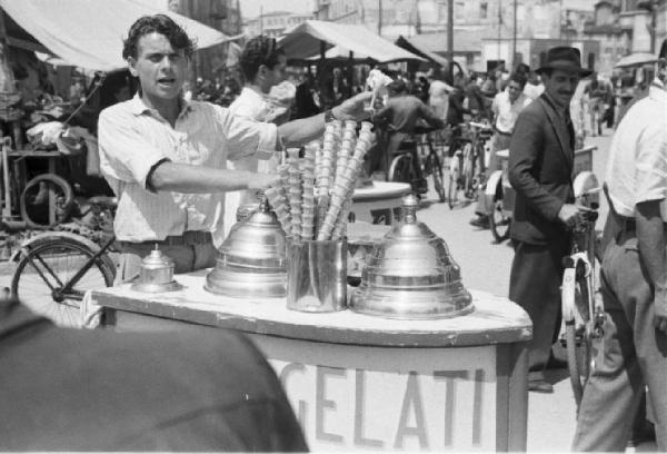 Milano. Gelatai con il carretto vendono i coni al mercato - sullo sfondo gente a piedi e in bicicletta