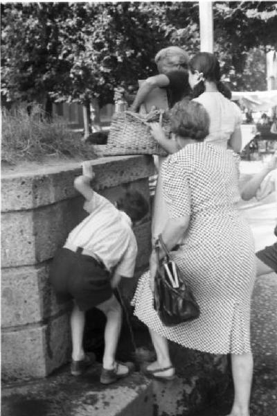 Milano. Parco Sempione. Donne e bambini alla "fontana dell'acqua marcia" - un ragazzino beve dal getto