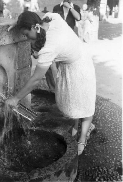 Milano. Parco Sempione. Una ragazza riempie la bottiglia alla "Fontana dell'acqua marcia"