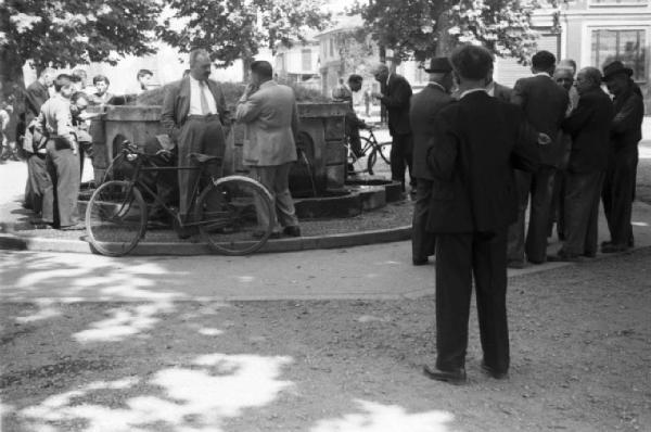 Milano. Parco Sempione. Gruppi di persone che discutono attorno alla "Fontana dell'acqua marcia" - biciclette parcheggiate attorno