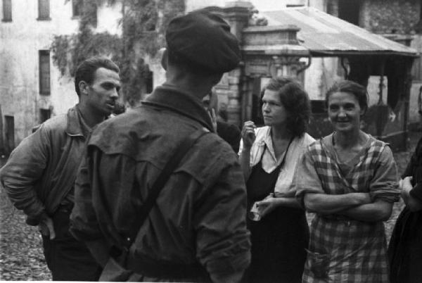 Movimento Resistenza Partigiana. Due partigiani chiacchierano con donne del paese