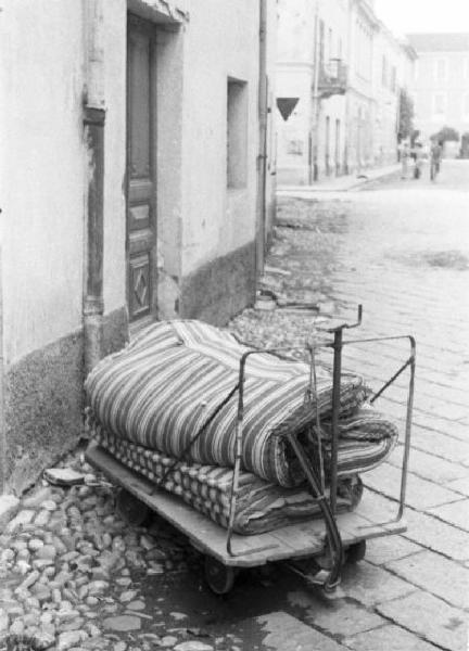 Diano Marina. Disinfezione. Strada del paese. Carrello con coperta e materasso abbandonato fuori dalla porta di casa