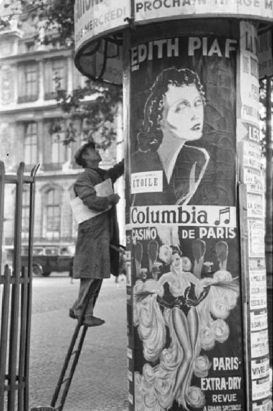 Parigi. Attacchino che affigge il cartellone di uno spettacolo di Edith Piaf