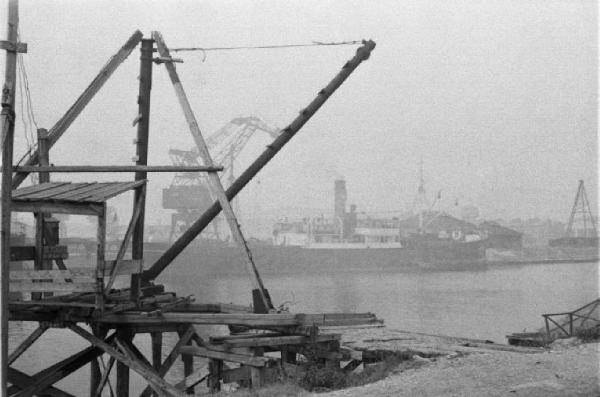 Porto Marghera. Strutture per il carico di materiali lungo le banchine e navi ormeggiate sullo sfondo