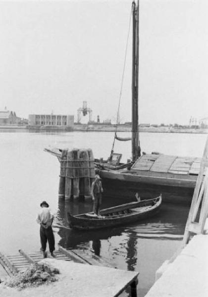 Porto Marghera. Veduta del bacino con barche ormeggiate e operai al lavoro