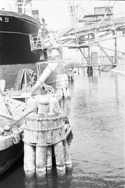 Porto Marghera. Strutture per il carico di materiali lungo le banchine. La nave Amabilitas ormeggiata