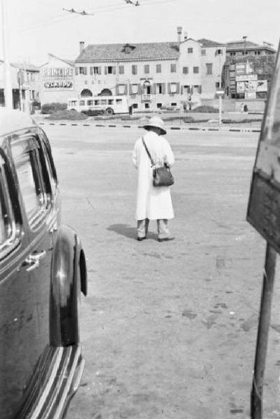 Posteggiatore presso un parcheggio di automobili. Edifici sullo sfondo