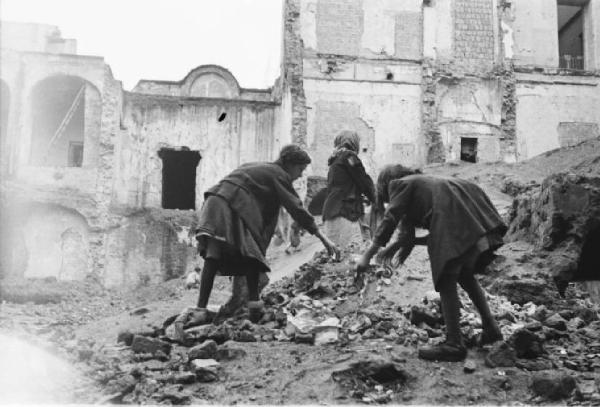 Italia Dopoguerra. Napoli. Ragazzine rovistano in un cumulo di macerie di edifici distrutti dai bombardamenti