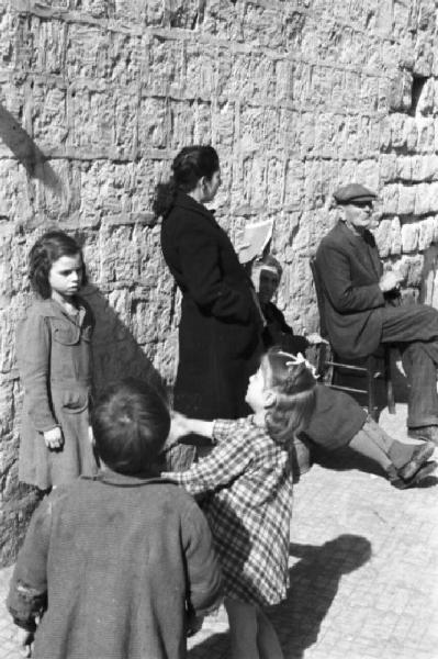 Italia Dopoguerra. Napoli. Bambini e anziani lungo le strade