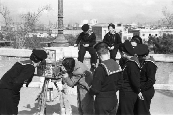 Italia Dopoguerra. Napoli. Un gruppo di marinai accanto a un fotografo ambulante