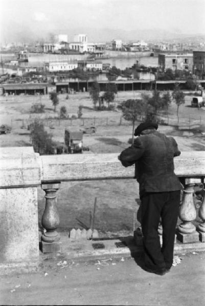 Italia Dopoguerra. Napoli. Un uomo affacciato a una balaustra guarda il panorama sottostante