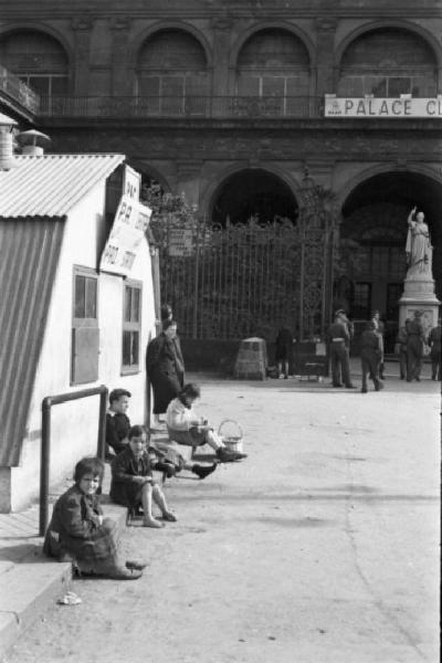 Italia Dopoguerra. Napoli. Baracca delle Forze Alleate in prossimità di Palazzo Reale - Bambini - In lontananza statua "L'Italia turrita e stellata" di Francesco Liberti