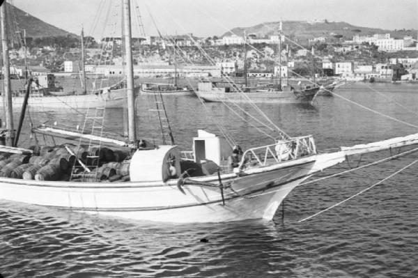 Italia Dopoguerra. Pozzuoli. Barca nel golfo trasporta botti di legno