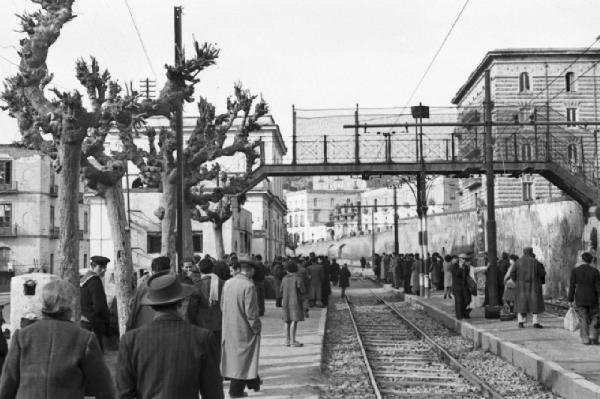 Italia Dopoguerra. Pozzuoli. Persone alla stazione attendono lungo la banchina il treno