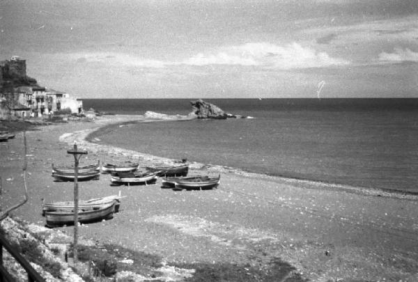 Italia Dopoguerra. Paesaggio marino. Insenatura con barche in secca sulla spiaggia e abitazioni