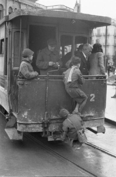 Italia Dopoguerra. Palermo. Ragazzini aggrappati all'esterno di un tram