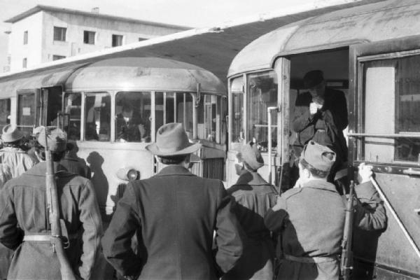 Italia Dopoguerra. Messina. Stazione ferroviaria. Due littorine ferme. Militari armati