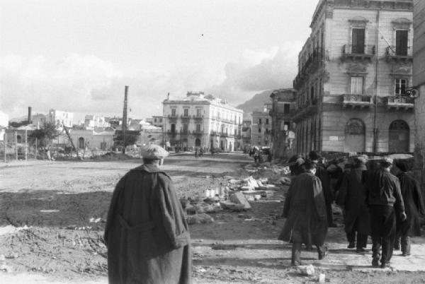 Italia Dopoguerra. Palermo. Scorcio di una via con macerie di edfici distrutti dai bombardamenti. Persone cammninano a lato