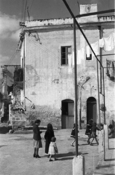 Italia Dopoguerra. Mondello. Scorcio del paese. Bambine giocano per la strada. Panni stesi ai balconi