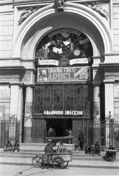 Italia Dopoguerra. Palermo. Portone d'ingresso del teatro Politeama. Un gelataio ambulante sosta davanti