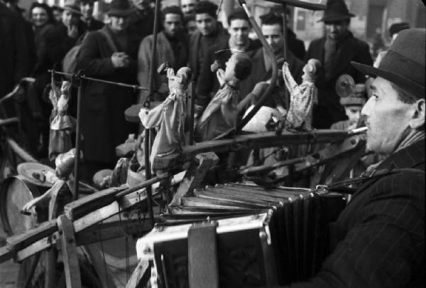 Italia Dopoguerra. Milano. Suonatore di fisarmonica-burattinaio