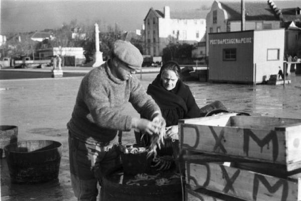 Portogallo. Cascais. Nei pressi del porto. Pescatore vende del pesce ad un' anziana