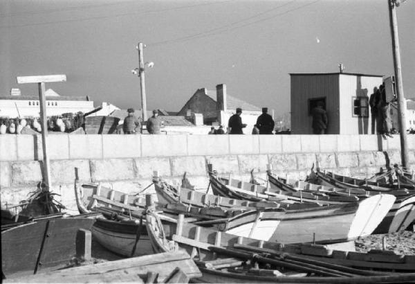 Portogallo. Cascais. Nei pressi del porto. Barche in secca sulla spiaggia - pescatori affacciati ad un muretto