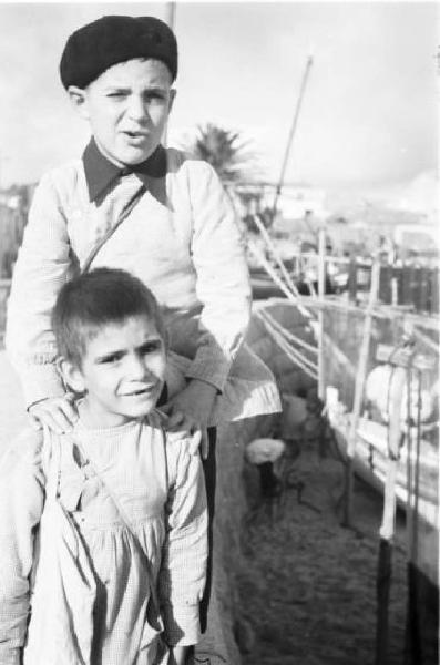 Portogallo. Cascais. Ritratto di due ragazzini fra le reti dei pescatori
