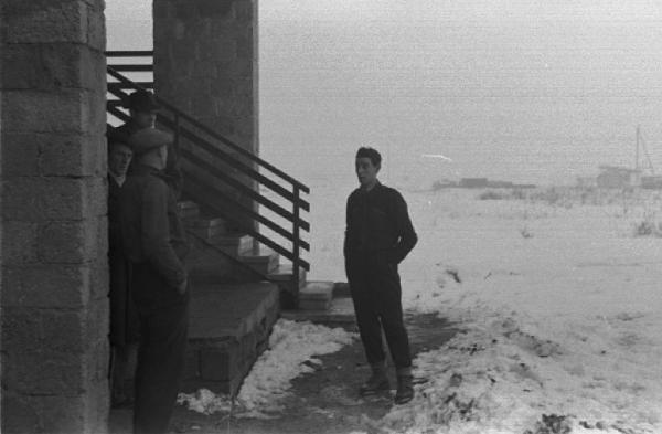 Operai all'ingresso di un edificio. Campi innevati