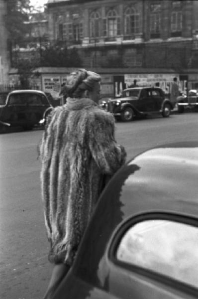 Parigi. Donna con pelliccia cammina lungo la strada