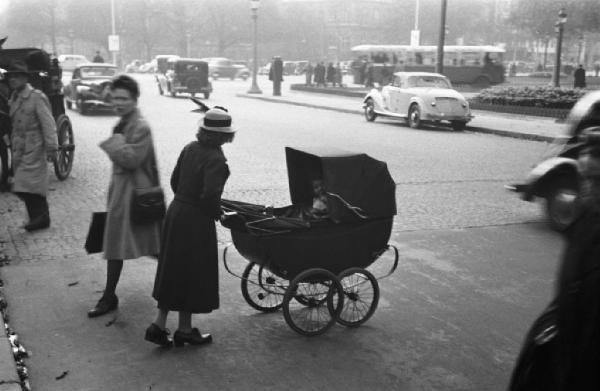 Parigi. Una donna con carrozzina attraversa la strada