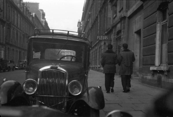 Parigi. Un'automobile parcheggiata. Due uomini camminano lungo una strada