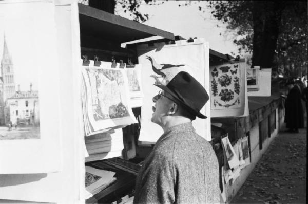 Parigi. Un uomo intento a guardare una stampa presso una libreria lungo la Senna