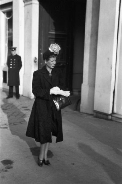 Parigi. Una donna elegante con cappello con fiore cammina lungo una strada