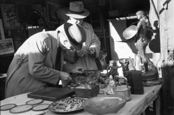 Le Vésinet. Il mercato delle pulci. Due persone guardano delle casse per orologio da tasca