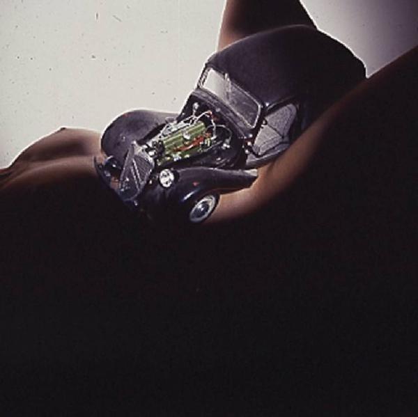 Modellino di automobile tra le gambe aperte di una donna