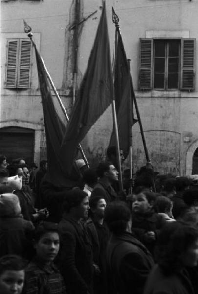 Roma. Folla di persone con bandiere che percorre una strada della città