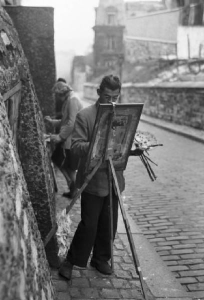 Parigi. Pittore al lavoro in una via di Montmartre