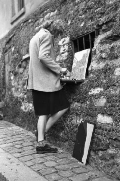 Parigi. Pittrice al lavoro in una via di Montmartre