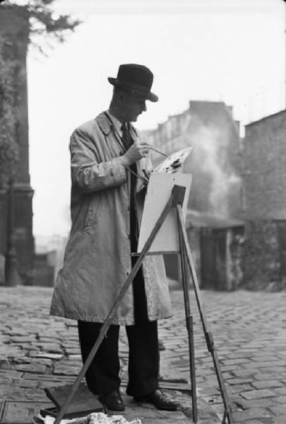 Parigi. Pittore al lavoro in una via di Montmartre