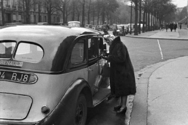 Parigi. Donna impellicciata che scende da un taxi