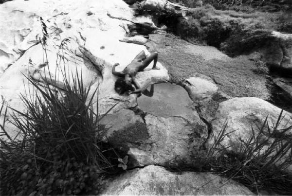 Val Verzasca - fotomodella nuda sdraiata all'interno di un massiccio roccioso