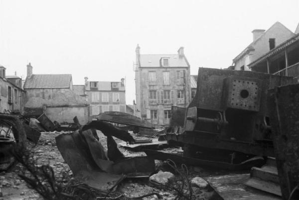 Normandia. Arromanches. Scorcio del paese e rottami di mezzi cingolati