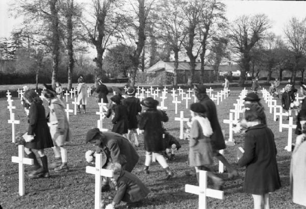 Normandia. St. Mère Eglise, cimitero di guerra. I bambini del paese recano fiori alle croci in occasione di una commemorazione religiosa in memoria dei caduti dello sbarco alleato