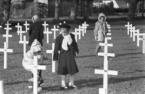 Normandia. Cimitero di guerra di St. Mère Eglise. Bambini del paese tra le croci in occasione della commemorazione religiosa in onore dei caduti dello sbarco alleato
