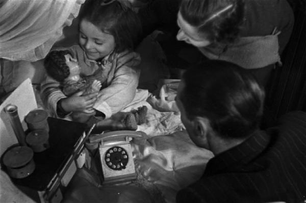 Genitori osservano una bimba felice per i doni ricevuti dalla befana
