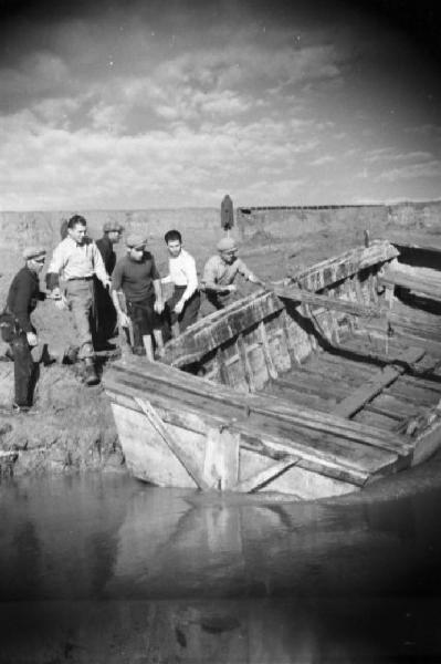 Italia Dopoguerra. Roma. Ponte sul Tevere in costruzione. Operai tirano in secca una chiatta lungo le sponde del fiume