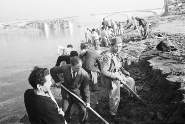 Italia Dopoguerra. Roma. Ponte sul Tevere in costruzione. Opere di consolidamento lungo le sponde del fiume. Squadre di operai che spalano. Sullo sfondo un ponte in costruzione